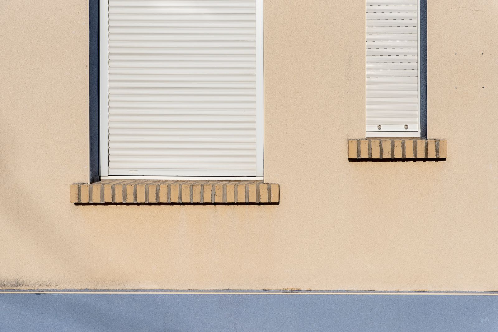 Hausfassade mit geschlossenen Rollläden an den Fenstern