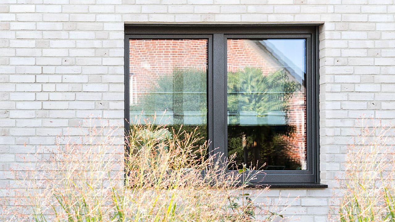 Anthrazitfarbenes Fenster in heller Klinkerfassade